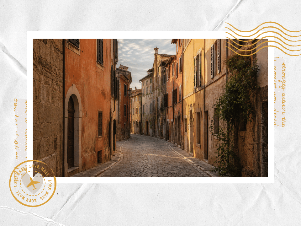 Narrow cobblestone street lined with warm-toned buildings in a European old town