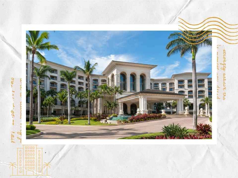 Resort hotel exterior with palm trees and columned entrance