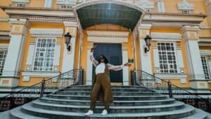Woman traveler posing on the steps of Ascension Cathedral during a visit to Almaty, Kazakhstan.