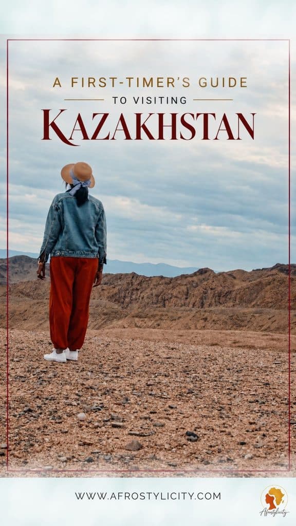 A first-timer’s guide to visiting Kazakhstan pin featuring a Black woman in a sun hat overlooking Kazakhstan’s rugged mountains and rocky terrain.