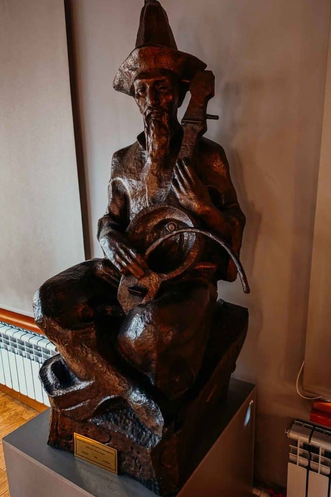 Bronze sculpture of a seated traditional Kazakh musician holding a stringed instrument, representing Kazakhstan’s cultural and musical heritage.