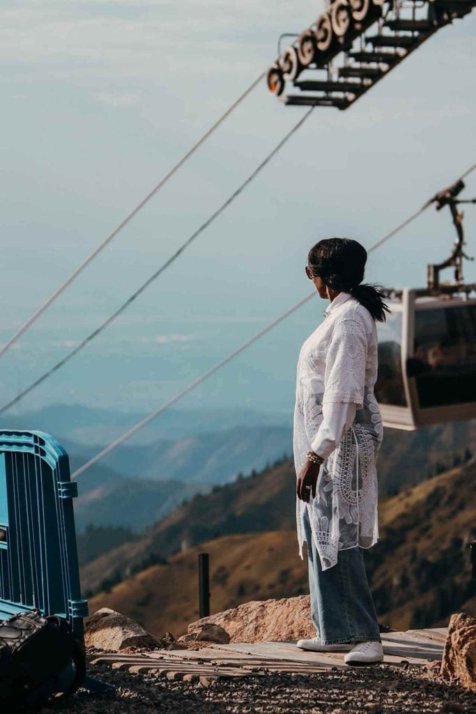 Woman looking toward the mountains beside a cable car at Shymbulak near Almaty, Kazakhstan.