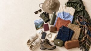 Stylish clothing, hiking gear, travel documents, and essential accessories arranged for a trip