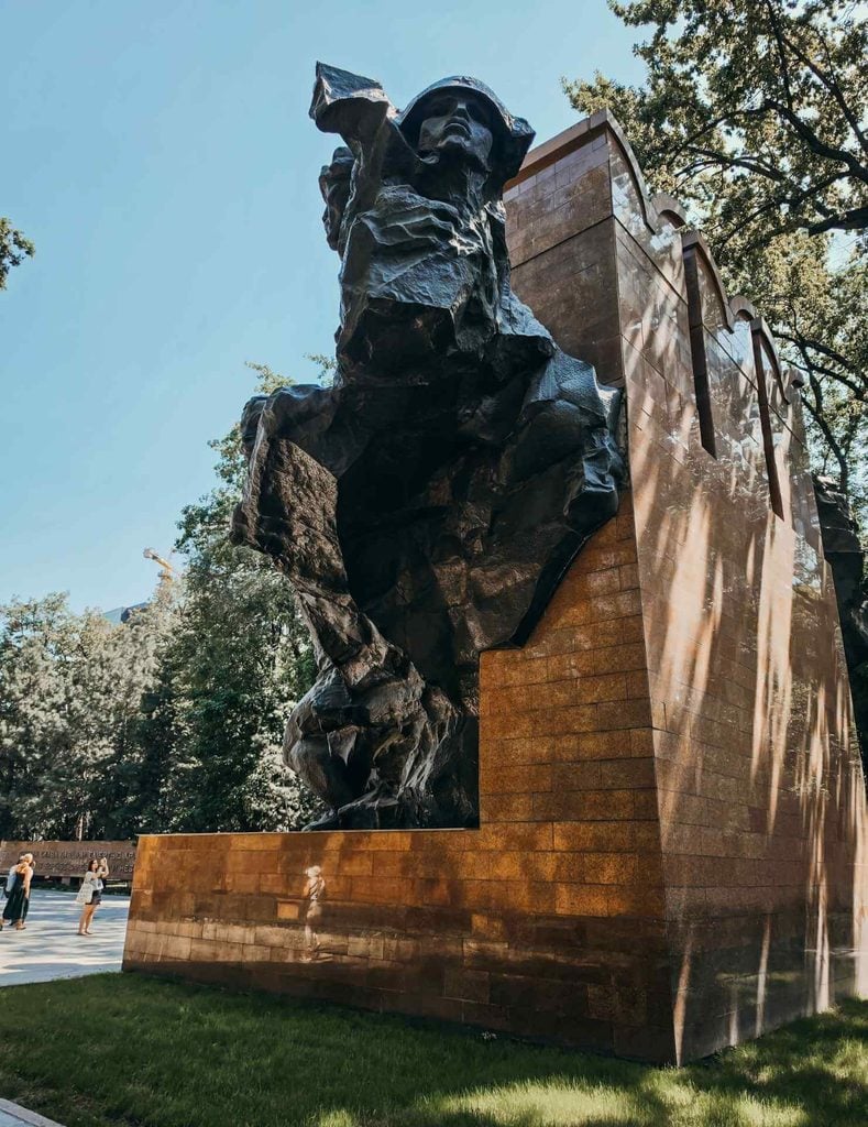 Close-up view of a monumental bronze soldier at the Memorial of Glory in Panfilov Park, Almaty.