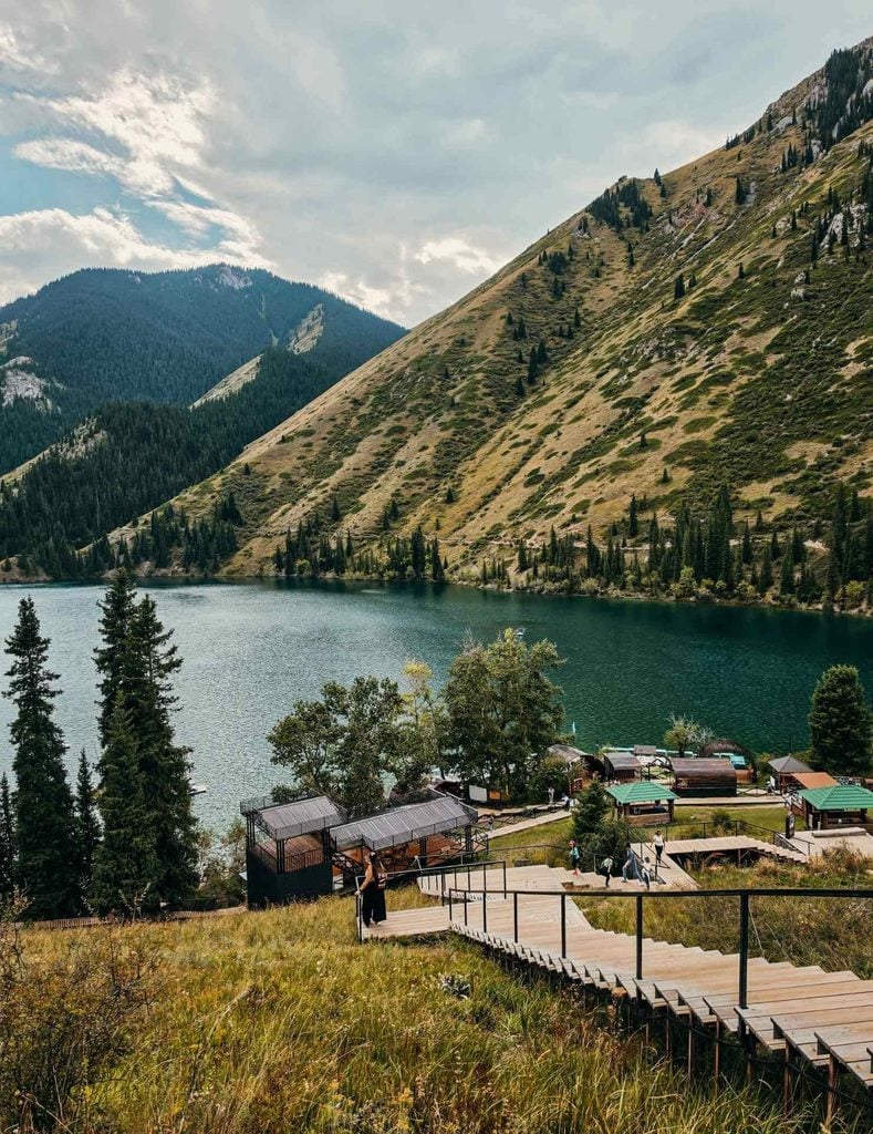 Lower Kolsai Lake surrounded by forested slopes and rugged mountains in southeastern Kazakhstan.